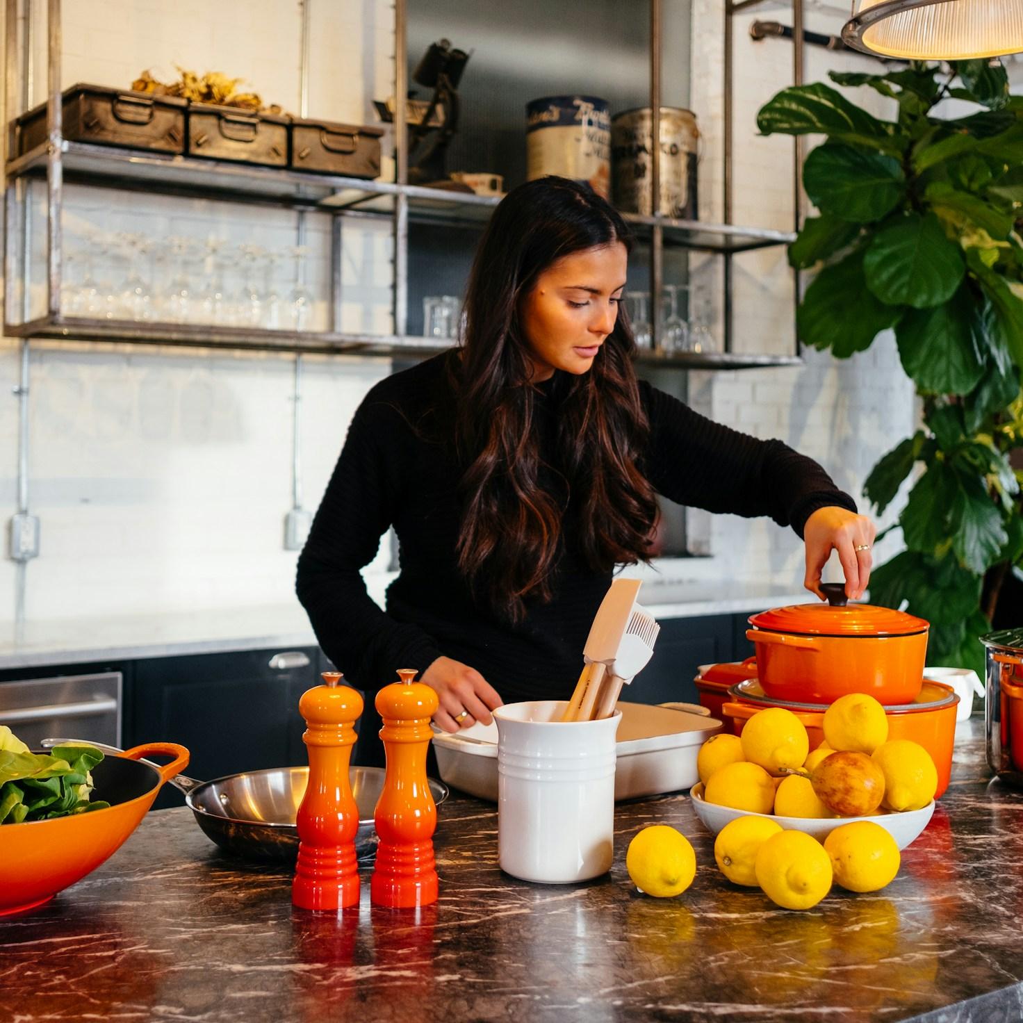 Community members collaborating in a contemporary kitchen, exchanging recipes and cooking techniques
